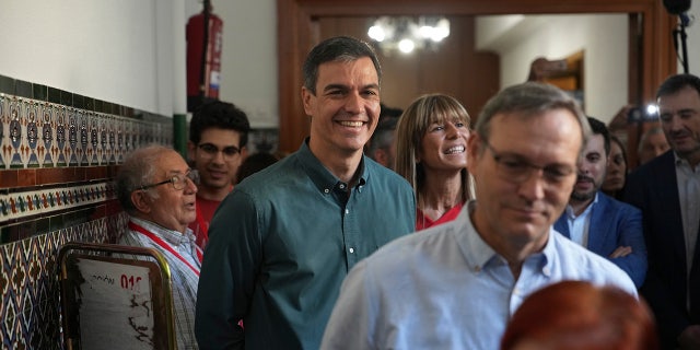 Spains Prime Minister Pedro Sanchez smiles for cameras upon arriving to the polling station