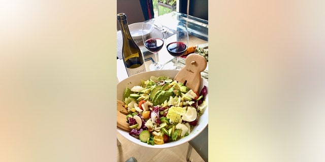 Brooke Burkes junk salad next to a glass and bottle of wine
