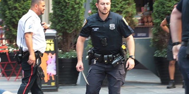New York City police officer holds a six-inch knife in Times Square.