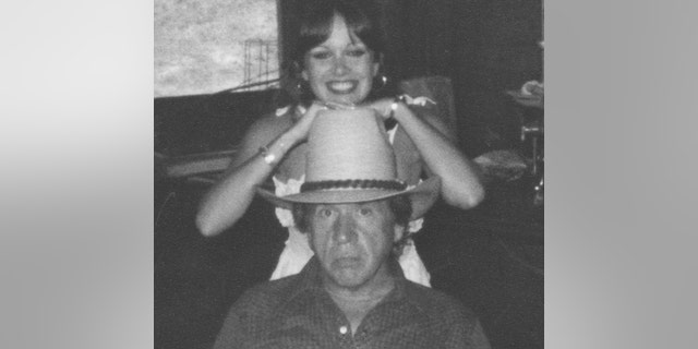 Victoria smiling, leaning on top of Buck Owens cowboy hat