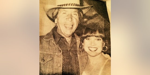 A classic photo of Buck Owens and Victoria Hallman smiling for the camera