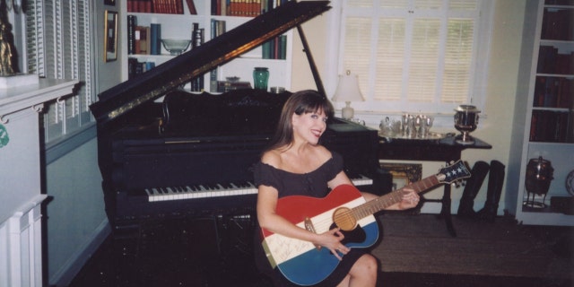 Victoria Hallman holding a guitar with the shades red, white and blue
