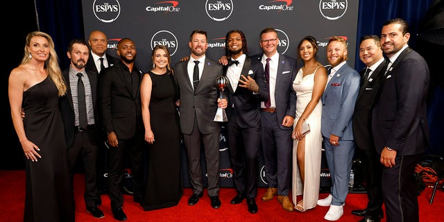 Damar Hamlin and the Bills coaching staff take a photo on the red carpet