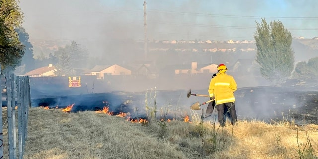 Firefighters put out flames near residential neighborhood