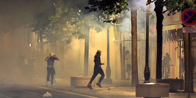 Protestors running away from smoke.