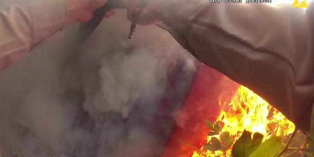 An officer saves a woman trapped in a burning car