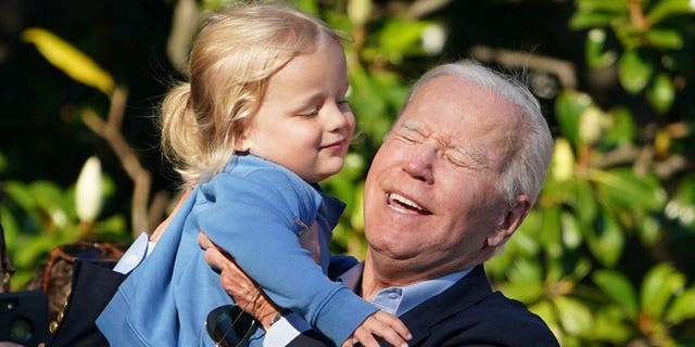 الرئيس الأمريكي جو بايدن يرفع حفيده بو