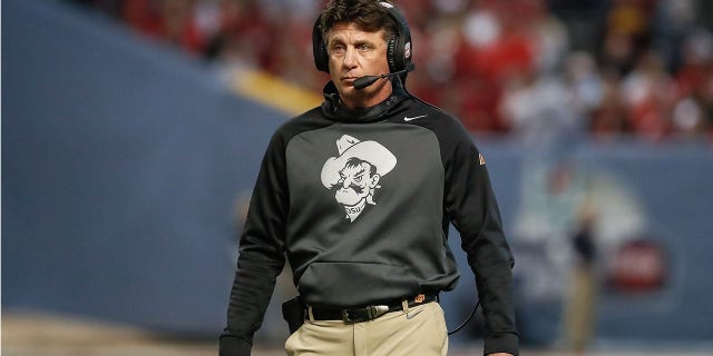 Mike Gundy loos on during a bowl game