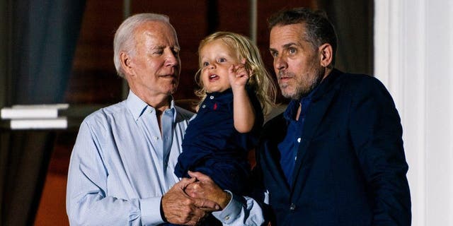 President Joe Biden holds his grandson Beau Biden with his son Hunter Biden