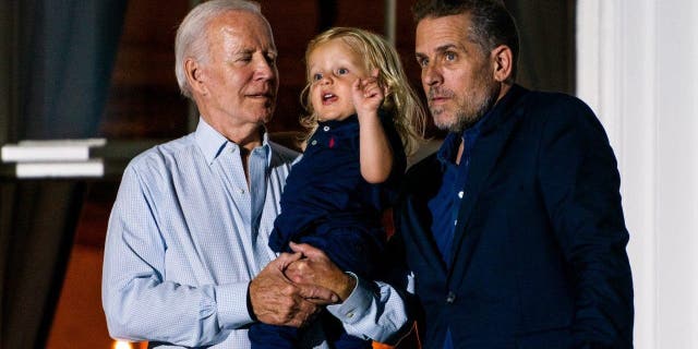 President Joe Biden holds his grandson Beau Biden with his son Hunter Biden