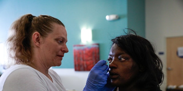La enfermera Michelle Absher (izquierda) administra un medicamento en el ojo de Breanna Blueford en la clínica Dore Urgent Care, que es un centro de atención de crisis para necesidades de salud mental en San Francisco, el 10 de junio de 2019.