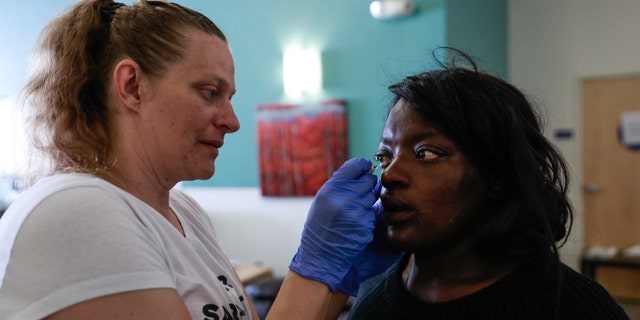 الممرضة ميشيل أبشر (يسار) تقدم الدواء لعين برينا بلوفورد في عيادة Dore Urgent Care ، وهي مركز استقبال للأزمات لاحتياجات الصحة العقلية في سان فرانسيسكو ، في 10 يونيو 2019.