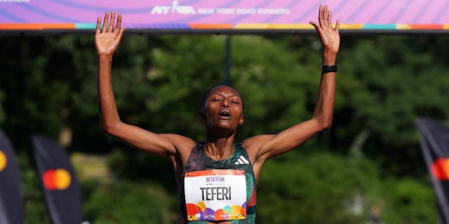 Senbere Teferi crosses the finish line of a race in New York