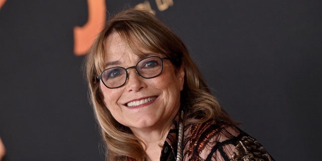 Karen Allen smiling and wearing glasses