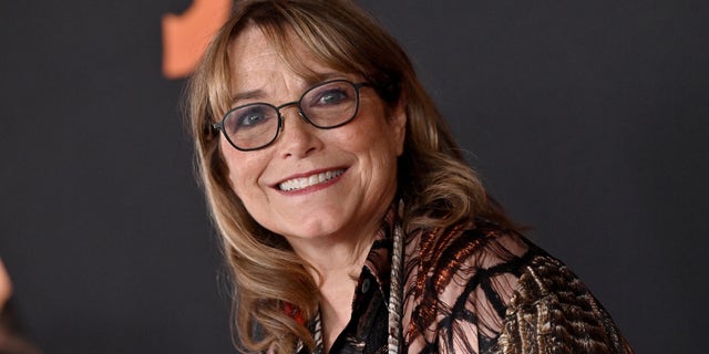 Karen Allen smiling and wearing glasses