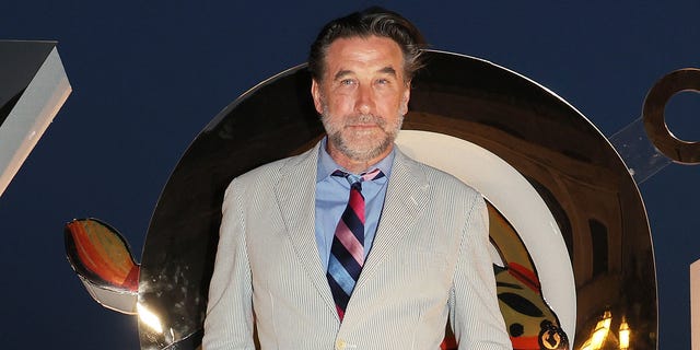 Billy Baldwin in a light jacket, blue shirt, and patterned tie