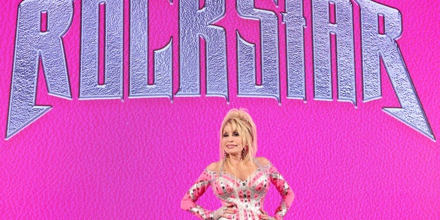 Dolly Parton in front of her Rockstar logo