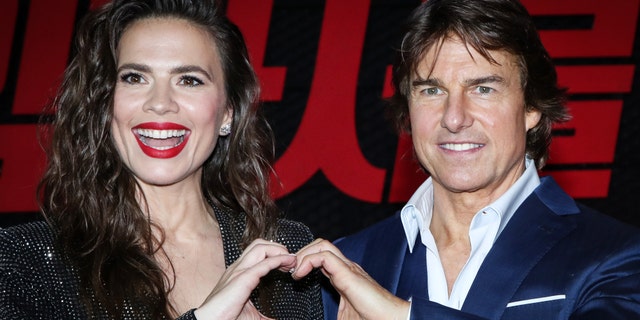 Tom Cruise and Haylet Atwell form a heart with their hands
