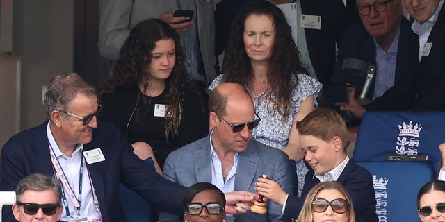 Prince George and Prince William with ceremonial Ashes urn during cricket match