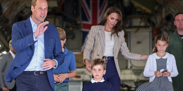 Prince William and Kate Middleton with their kids on a large aircraft