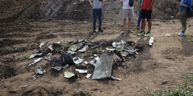 fragments of missile in street with onlookers