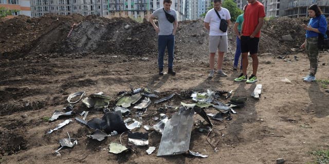 fragments of missile in street with onlookers