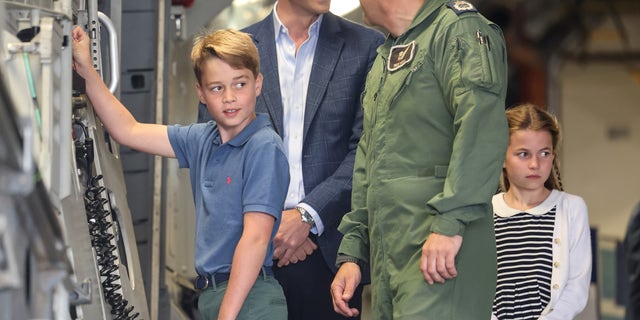 A photo of Prince William and Prince George looking at aircraft controls