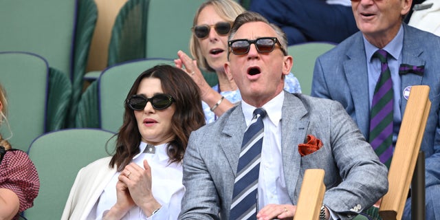 Rachel Weisz and Daniel Craig wear sunglasses in the stands at Wimbledon.