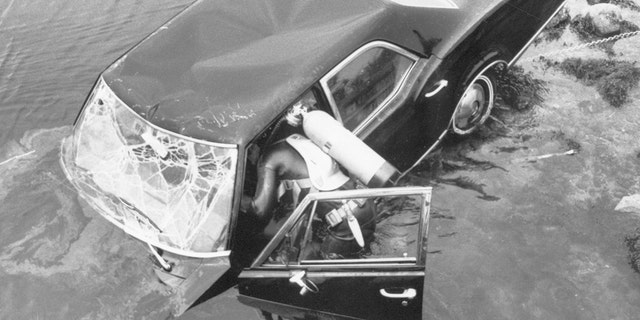 crashed car being inspected by a diver