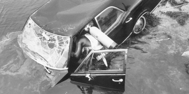 crashed car being inspected by a diver