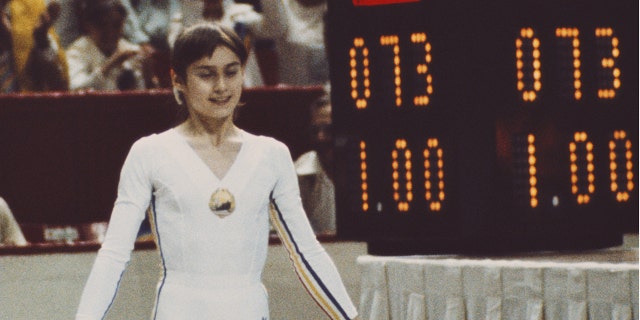 nadia standing by scoreboard reading 1.00