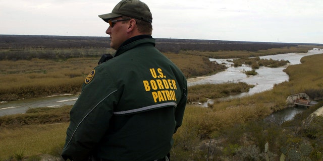 Un funcionario de la USBP junto a un río