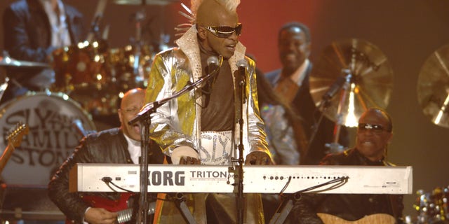 Sly Stone performs onstage with yellow mohawk