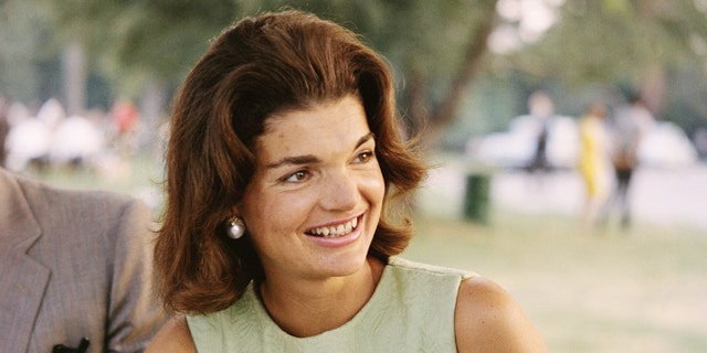 Jackie Kennedy looks to her left in a light green outfita