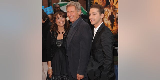 Karen Allen, Harrison Ford, and Shia LaBeouf pose together on the red carpet.