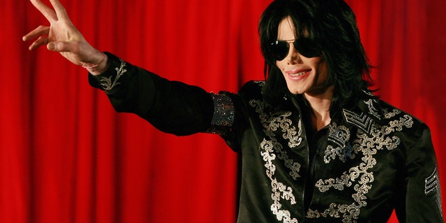 Michael Jackson wearing sunglasses and giving peace sign