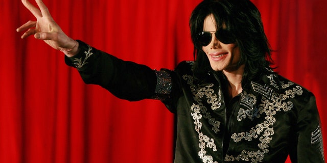 Michael Jackson wearing sunglasses and giving peace sign