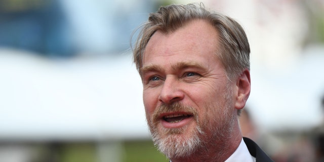 Christopher Nolan looks off in the distance at Cannes Film Festival in a tuxedo