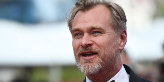 Christopher Nolan looks off in the distance at Cannes Film Festival in a tuxedo
