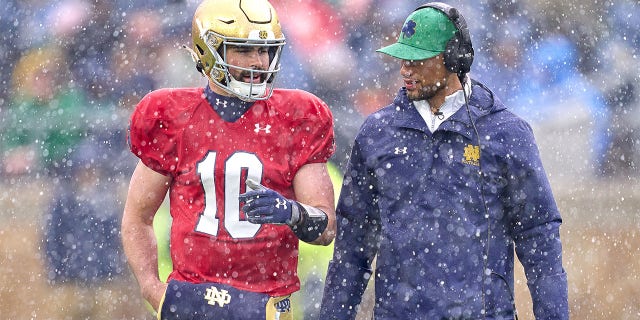 Sam Hartman talks with head coach Marcus Freeman