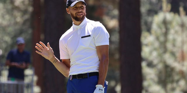 Stephen Curry waves after a tee shot