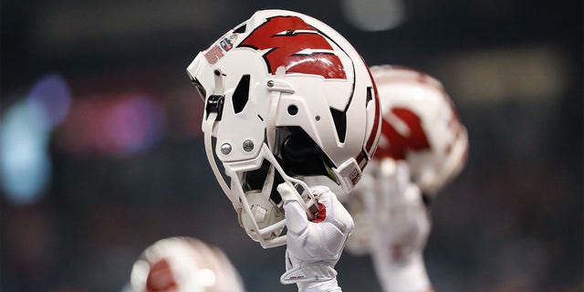 A player holds up his Wisconsin helmet