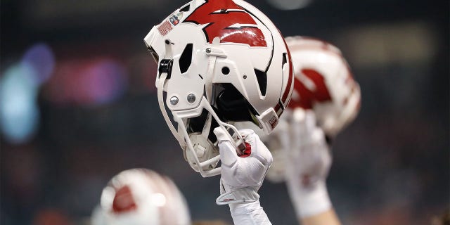 A player holds up his Wisconsin helmet