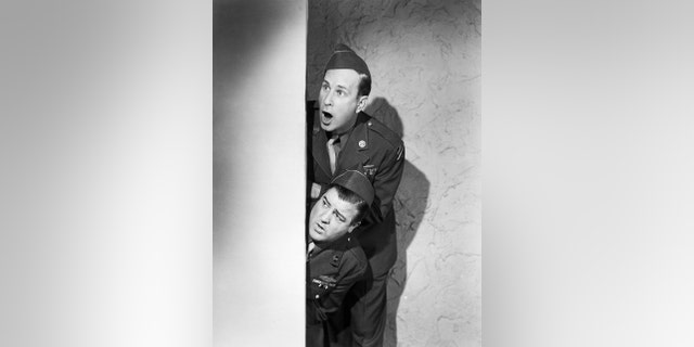 Bud Abbott and Lou Costello wearing military uniforms while looking surprised in a comedy skit