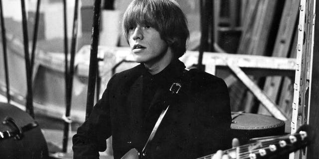 A close-up of Brian Jones playing the guitar