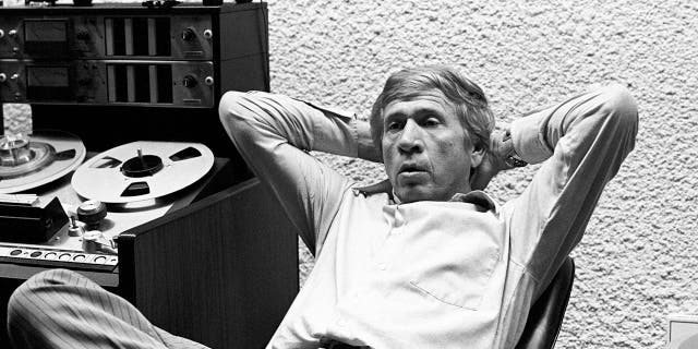 Buck Owens leaning back on a chair in his recording studio
