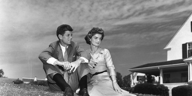 Jackie Kennedy and Jack Kennedy sitting outside next to each other