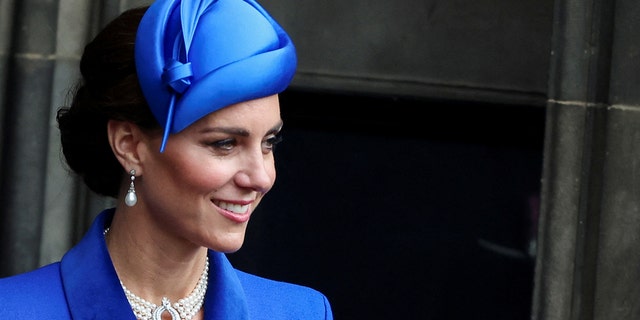 A close-up of Kate Middleton in blue wearing a pearl choker