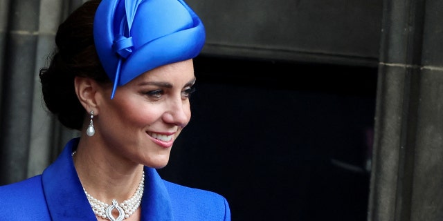 A close-up of Kate Middleton in blue wearing a pearl choker