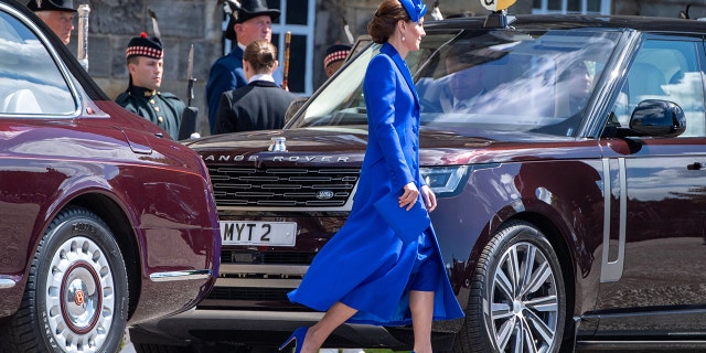 Kate Middleton wearing a blue dress leaving a car